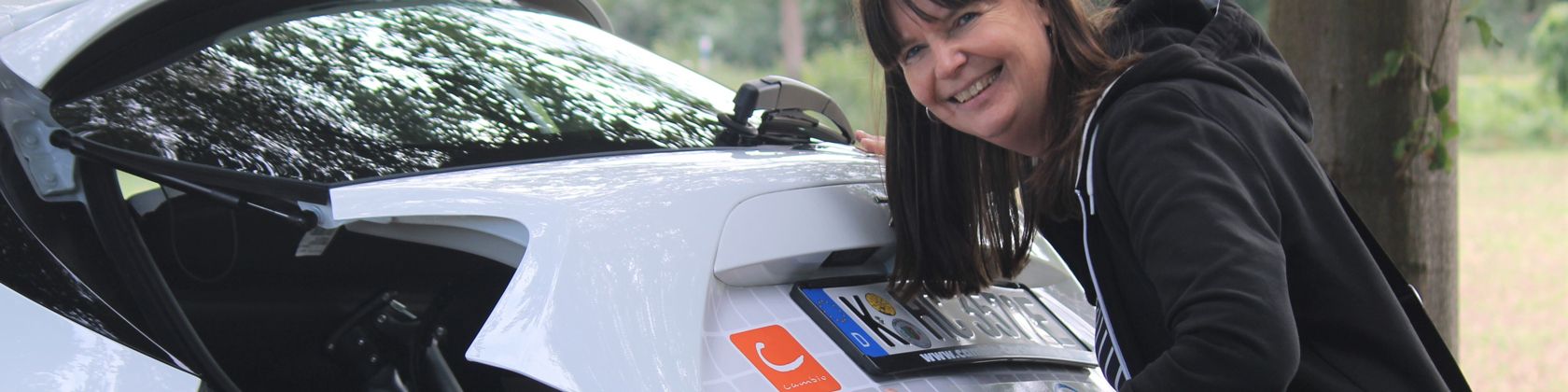 Frau schließt den Kofferraum eines Car-Sharing-Fahrzeugs Frau schließt den Kofferraum eines Car-Sharing-Fahrzeugs
