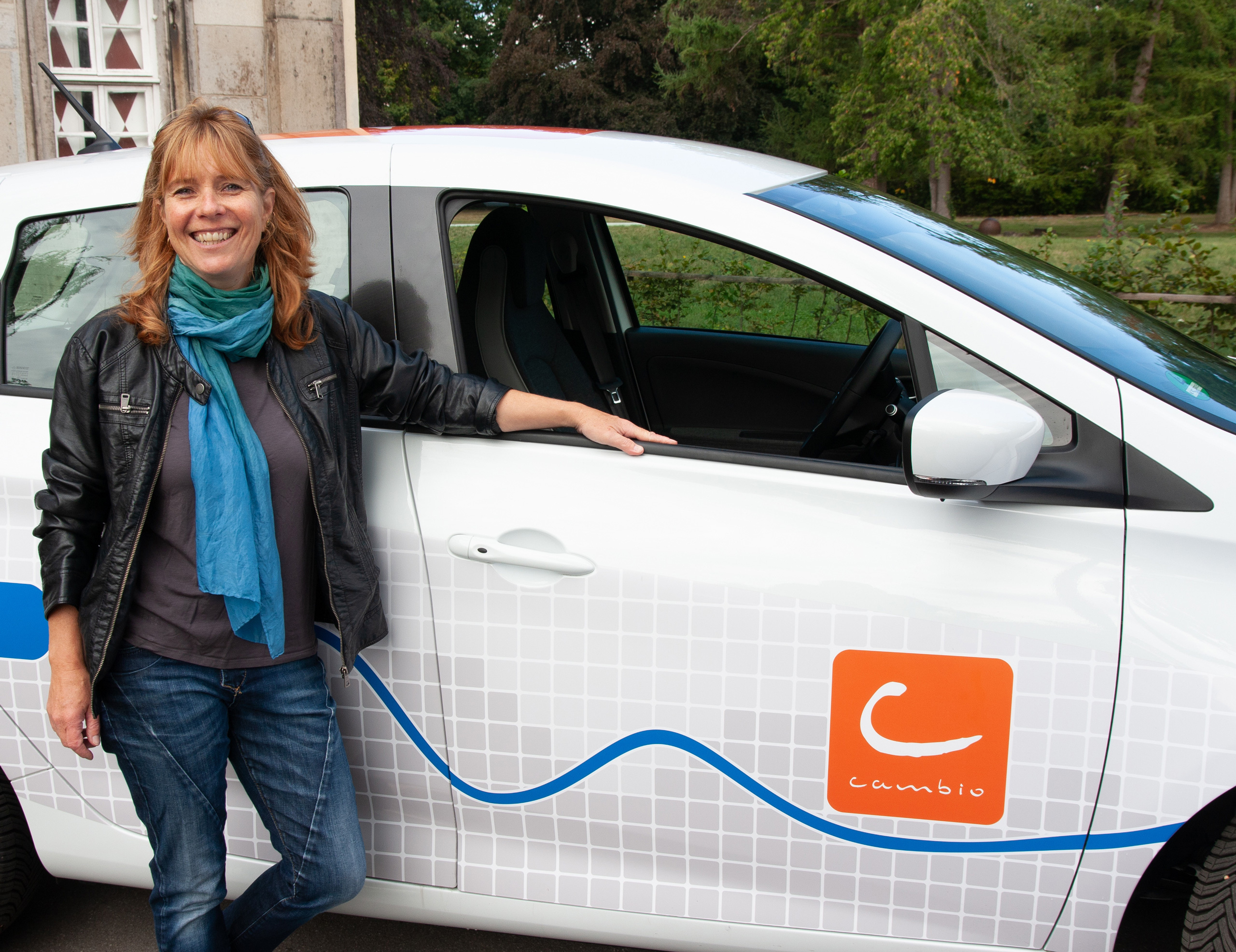 Frau steht vor einem Car-Sharing-Fahrzeug Frau steht vor einem Car-Sharing-Fahrzeug