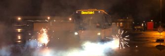 Bus bei Nacht mit Feuerwerk